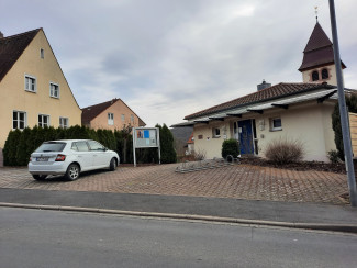 Das evang. Gemeindehaus mit den Parkplätzen